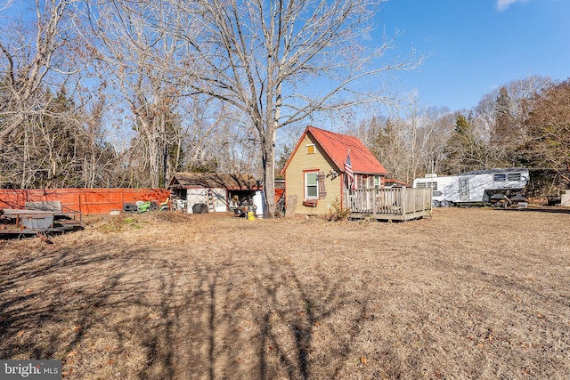 view of yard with a shed, fence, an outdoor structure, and a wooden deck