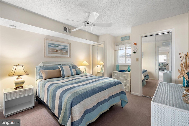 carpeted bedroom with visible vents, a textured ceiling, and ceiling fan