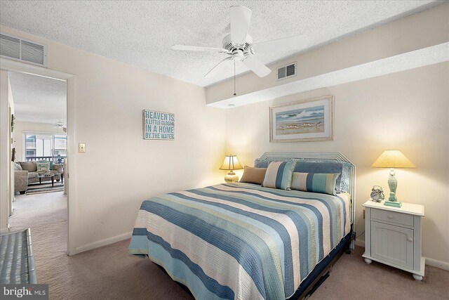 bedroom featuring baseboards, visible vents, carpet floors, and a textured ceiling