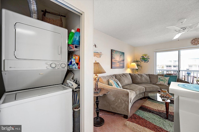 living room with ceiling fan, carpet, stacked washer / drying machine, and a textured ceiling