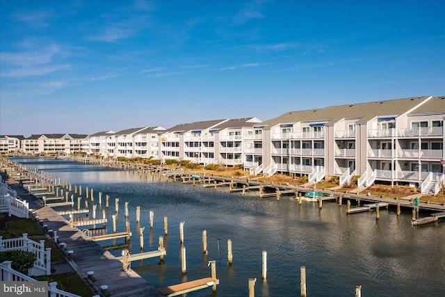 view of dock with a residential view and a water view