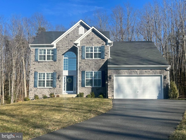 view of front of house featuring aphalt driveway, a front yard, roof with shingles, stone siding, and an attached garage