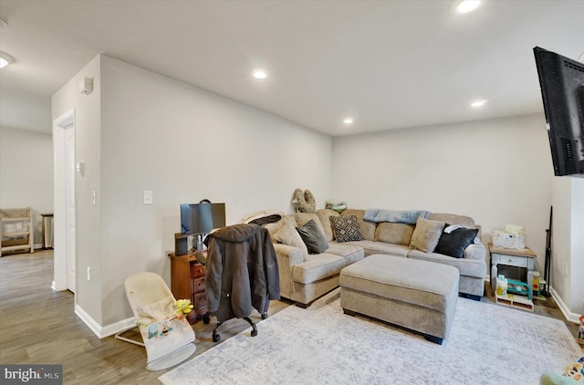 living area featuring recessed lighting, baseboards, and wood finished floors