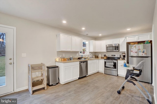 kitchen featuring stainless steel appliances, light wood-type flooring, white cabinetry, and recessed lighting