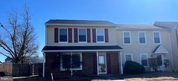 view of front of home with fence and brick siding