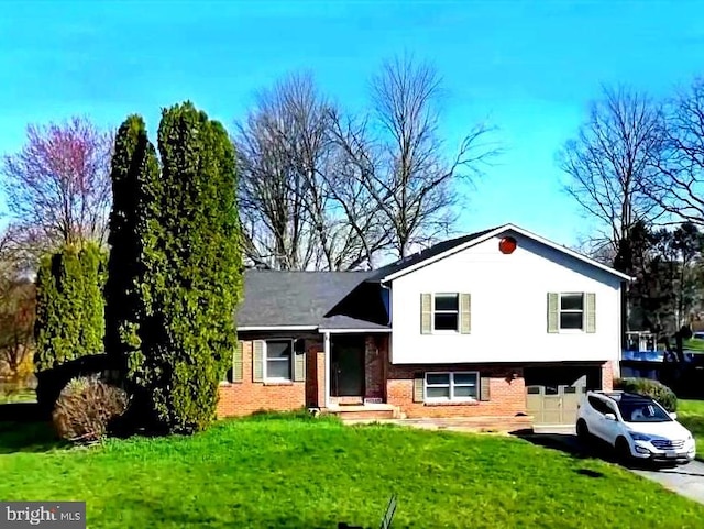 tri-level home featuring driveway, an attached garage, a front lawn, and brick siding