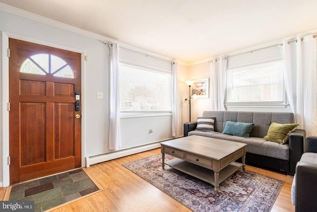 foyer entrance featuring a wealth of natural light, a baseboard heating unit, and light wood finished floors