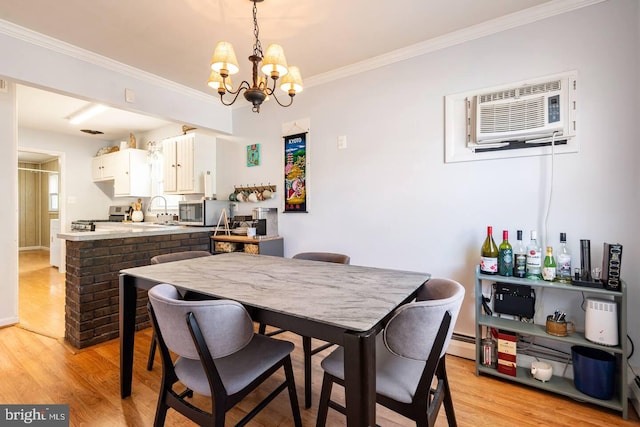 dining area featuring light wood finished floors, baseboard heating, a chandelier, and a wall unit AC