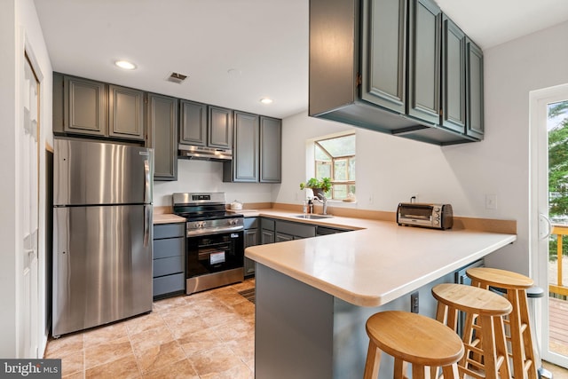 4504 Little River Run Dr, Annandale, VA 22003 - kitchen with stainless steel appliances, under cabinet range hood, a peninsula, a sink, and light countertops