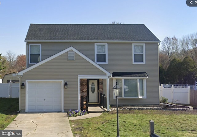 view of front of home with driveway, fence, roof with shingles, an attached garage, and a front yard