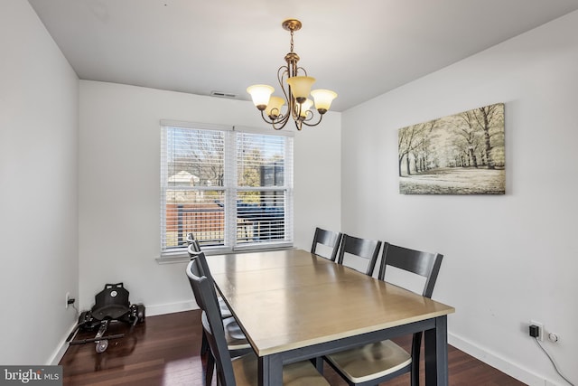 dining room with dark wood-style floors, visible vents, a chandelier, and baseboards