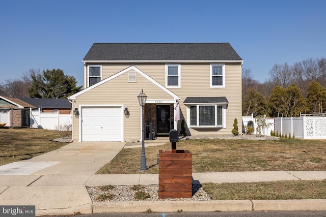 traditional-style home with a front lawn, fence, a garage, and driveway