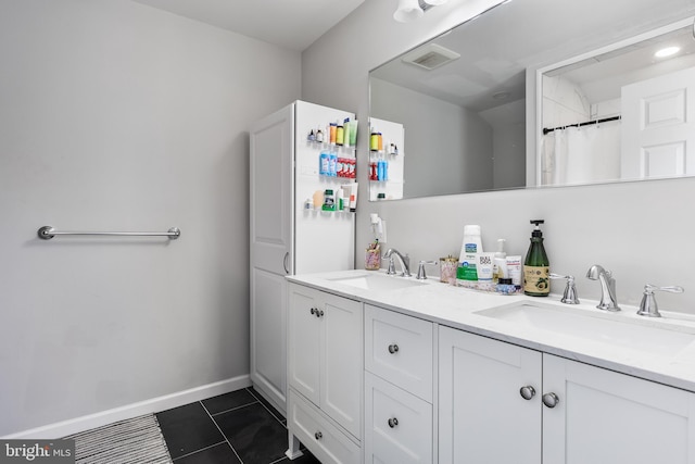 bathroom with tile patterned flooring, double vanity, visible vents, and a sink