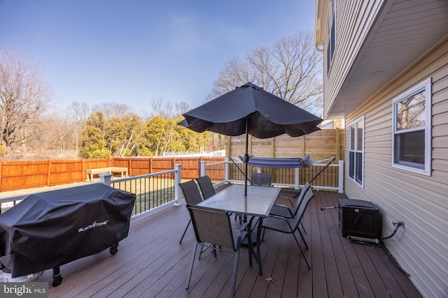 wooden deck featuring a fenced backyard, area for grilling, and outdoor dining space