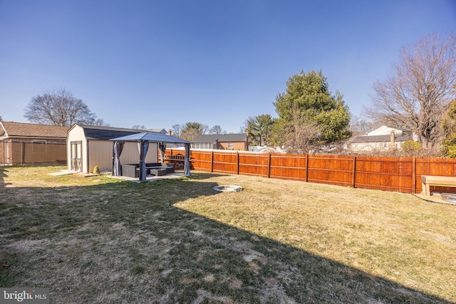 view of yard with a storage unit, a fenced backyard, and an outdoor structure