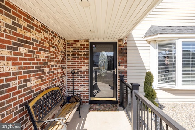 view of exterior entry featuring brick siding