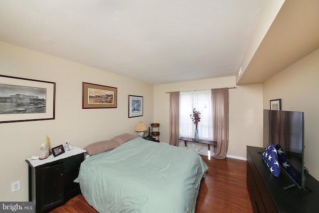 bedroom featuring dark wood-style floors and baseboards