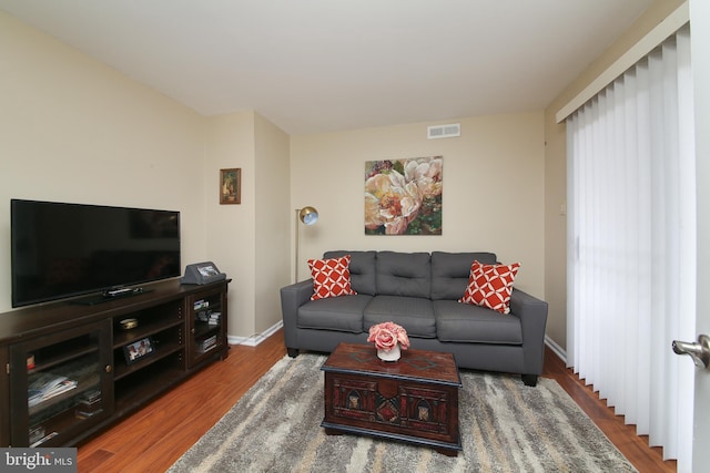 living area with visible vents, baseboards, and wood finished floors