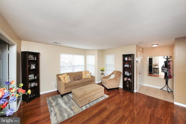 living area featuring wood finished floors, visible vents, and baseboards