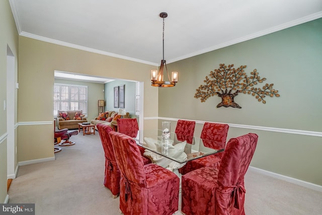 carpeted dining area with baseboards, crown molding, and an inviting chandelier