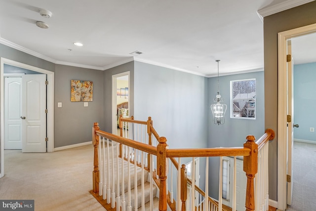 hallway featuring baseboards, ornamental molding, light carpet, a notable chandelier, and an upstairs landing