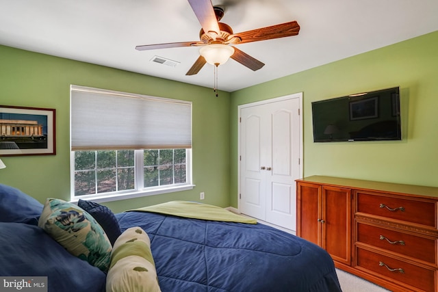 bedroom featuring visible vents, light colored carpet, and ceiling fan