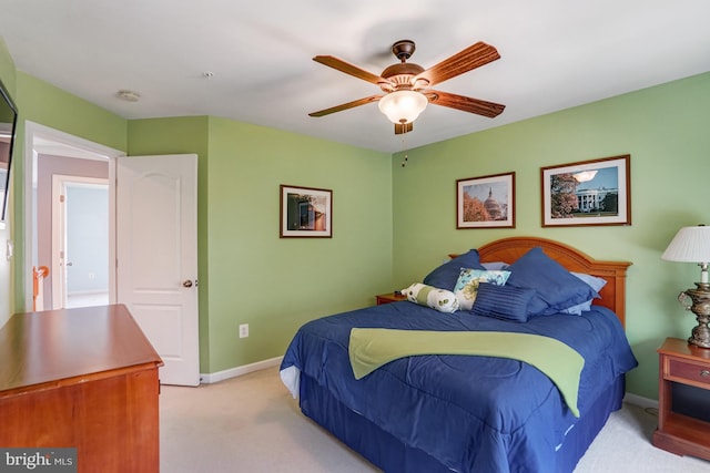 bedroom with light colored carpet, baseboards, and ceiling fan