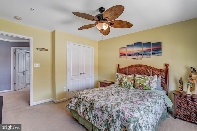 carpeted bedroom with a closet, ceiling fan, and baseboards