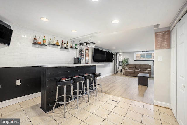 bar with light tile patterned floors, a dry bar, and recessed lighting