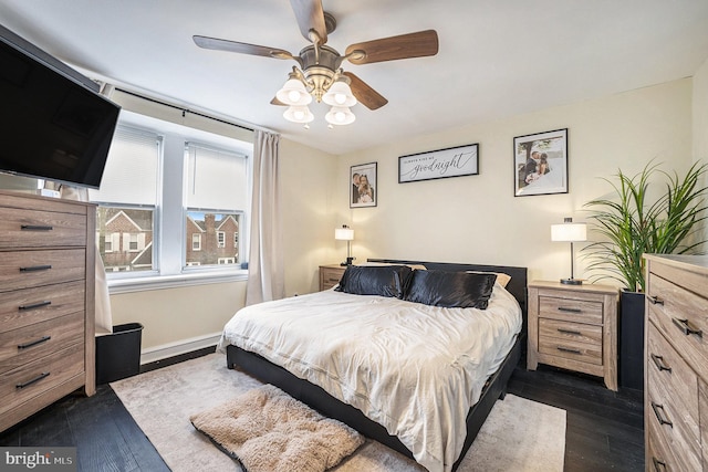 bedroom featuring dark wood-style floors, baseboards, and a ceiling fan