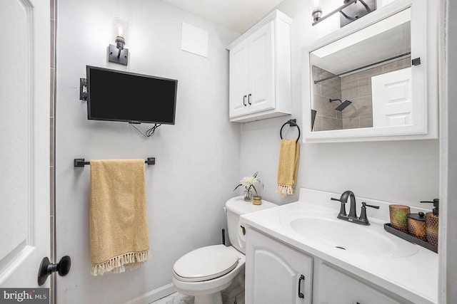 bathroom featuring toilet, walk in shower, and vanity