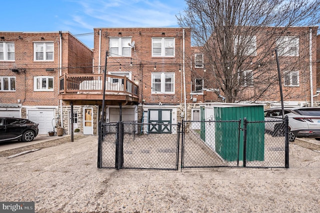 view of front of home with an attached garage, a fenced front yard, a gate, and brick siding