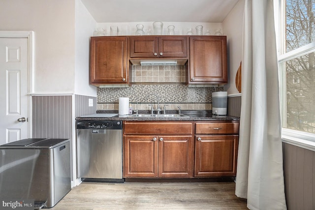 kitchen with light wood-type flooring, brown cabinets, stainless steel appliances, and a sink