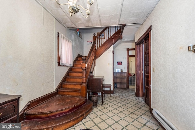 stairway featuring a baseboard radiator and a notable chandelier