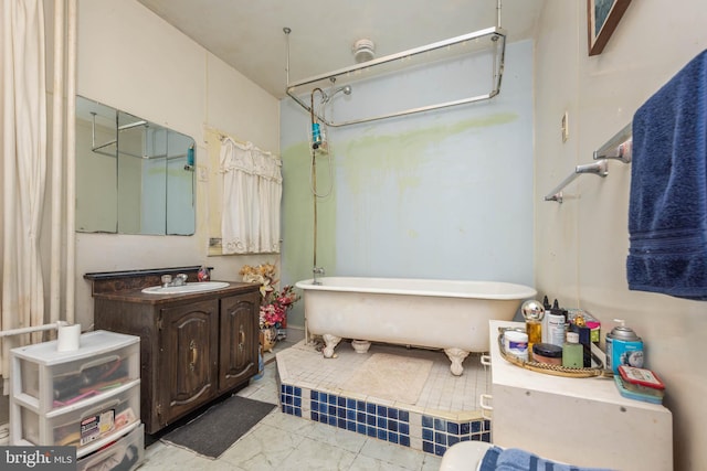 bathroom featuring marble finish floor, a freestanding bath, vanity, and walk in shower