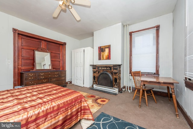 carpeted bedroom with a ceiling fan and a fireplace