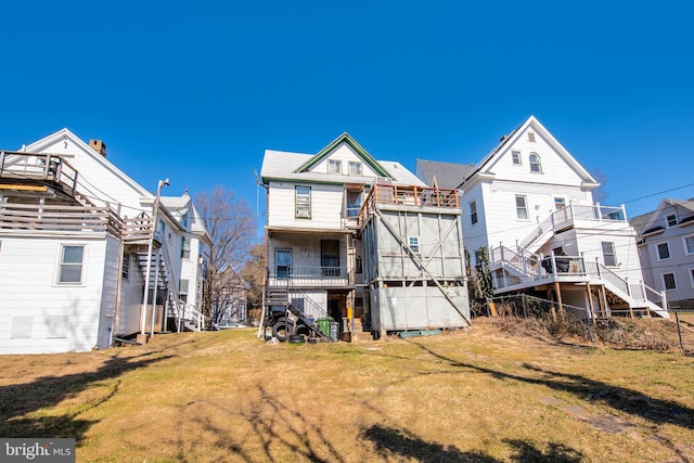 rear view of property with a yard and stairway