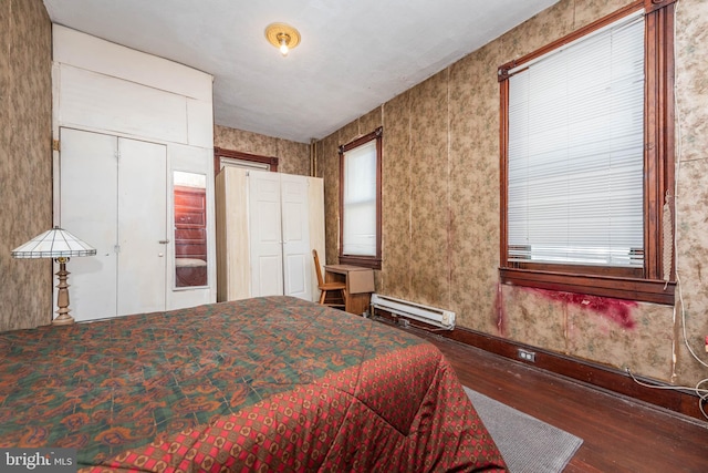 bedroom featuring a baseboard radiator and wood finished floors