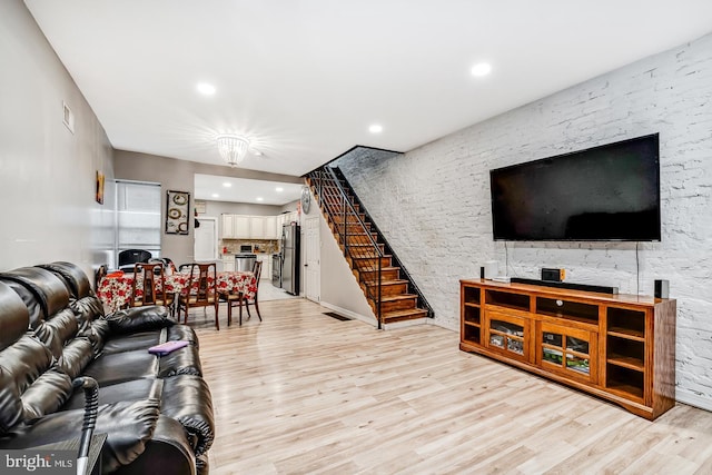 living room with light wood-style floors, recessed lighting, visible vents, and stairs