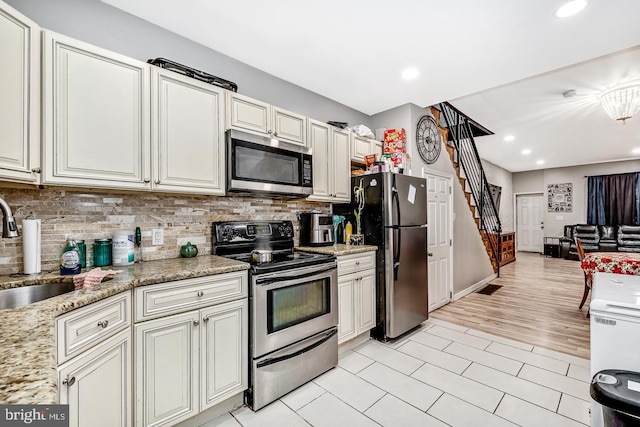 kitchen featuring decorative backsplash, stainless steel appliances, a sink, and recessed lighting