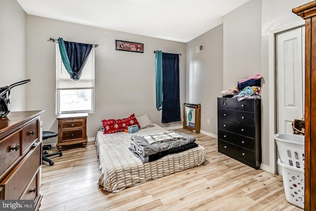 bedroom with light wood-type flooring, visible vents, and baseboards