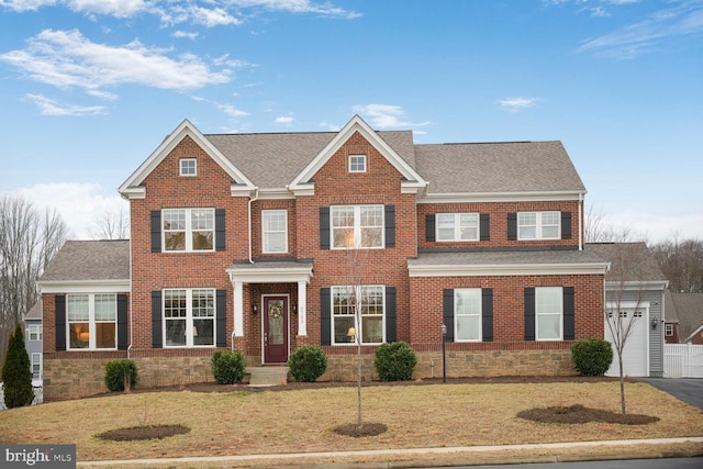 view of front of house with a front lawn, aphalt driveway, and brick siding