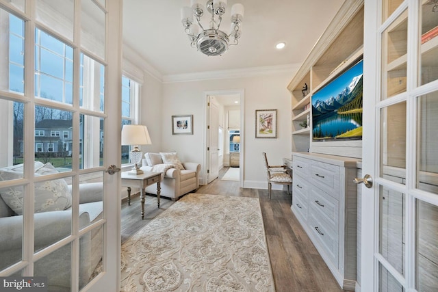 living area with ornamental molding, french doors, a notable chandelier, and dark wood-style flooring