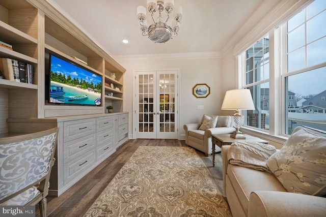 living area with a chandelier, french doors, dark wood-style flooring, and crown molding