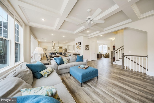 living room with stairs, coffered ceiling, beamed ceiling, and wood finished floors