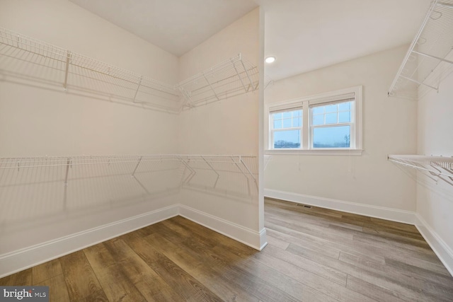 spacious closet featuring wood finished floors and visible vents