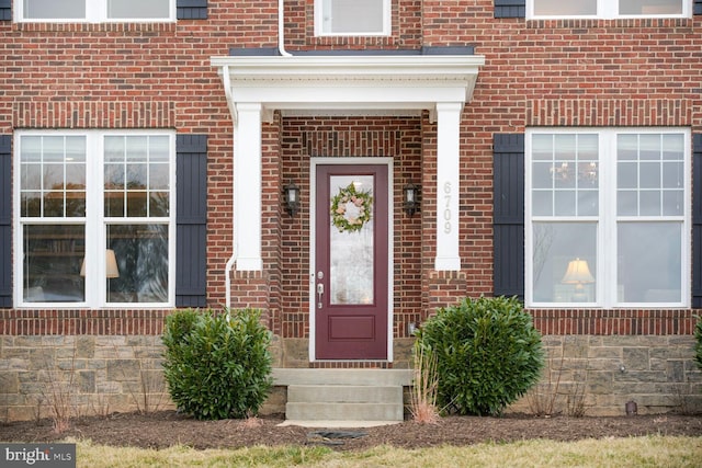 entrance to property featuring brick siding