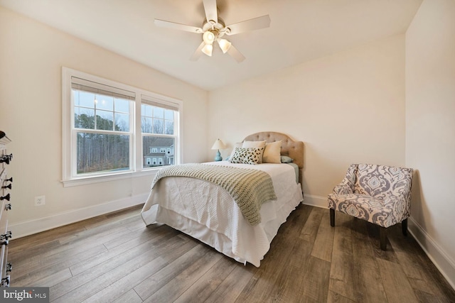 bedroom featuring a ceiling fan, baseboards, and wood finished floors