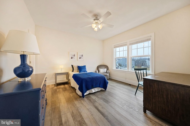 bedroom with ceiling fan, baseboards, and wood finished floors