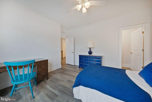 bedroom with ceiling fan, wood finished floors, and baseboards